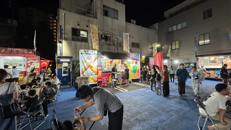 阿波おどり期間中の夜の街なか。屋台が並び、人が行き交っている様子。